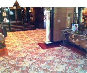 Custom rose floral carpet area rug featured in NJ design magazine — formal entry with pedestal bust